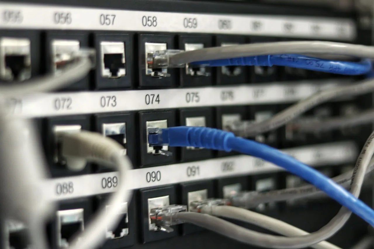 Patch panel with numbered ports and network cabling in a comms rack